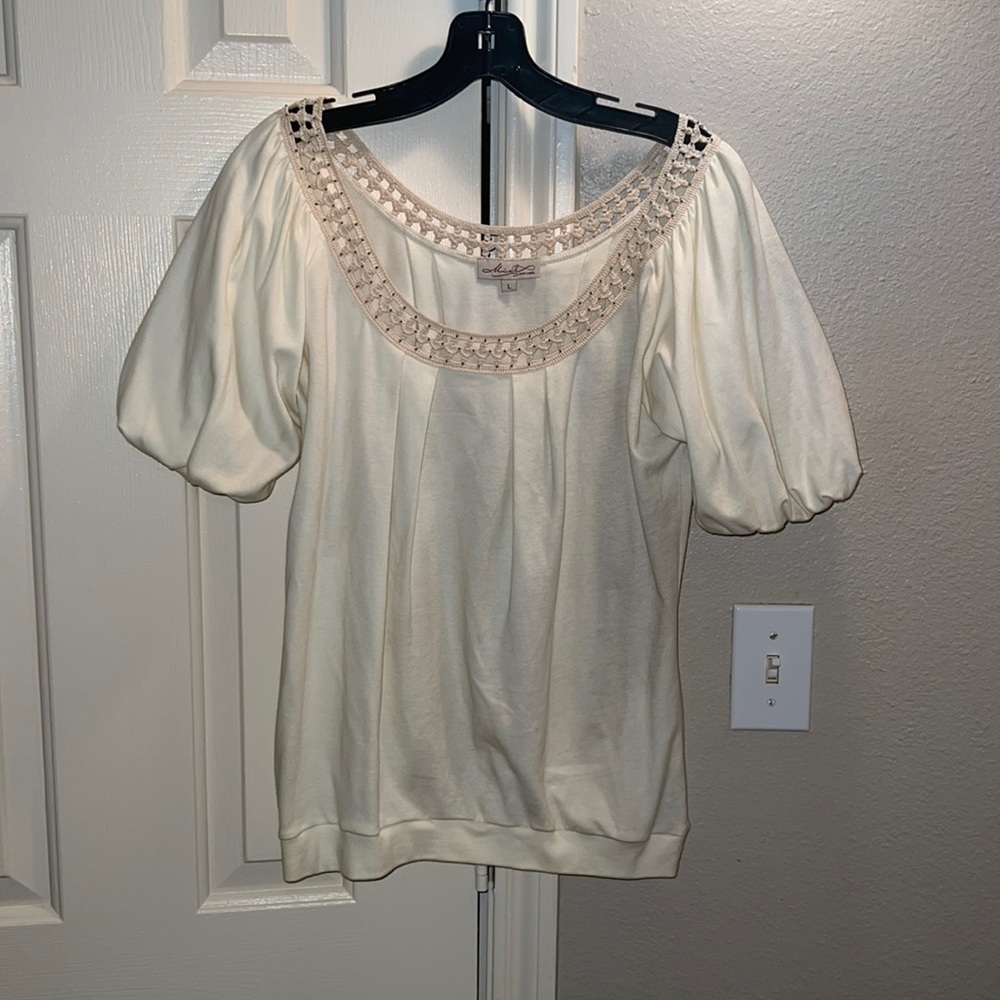 Ivory colored top with decorative neckline